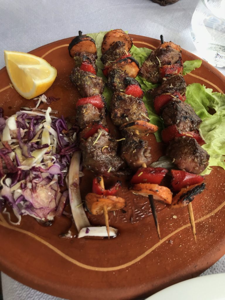 A wonderful and tasty shish kebab of beef, pepper and carrot, sided with a purple slaw and lemon wedge.